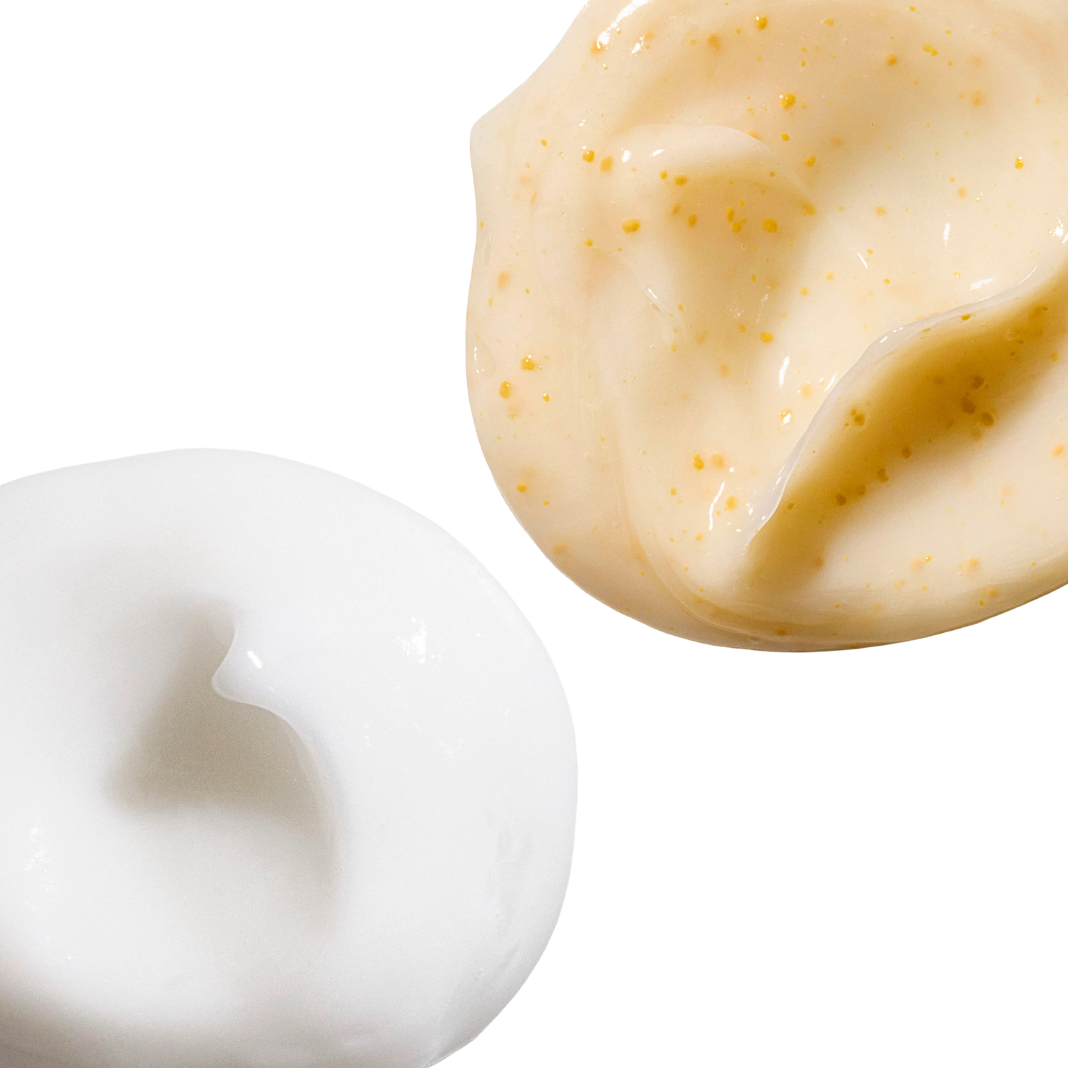 Swatches of a variety of haircare products are displayed on a white background. One is a creamy white, and the other is yellowish with tiny specks.