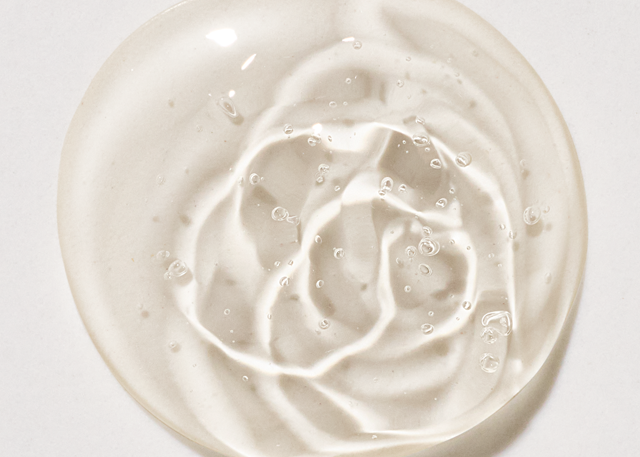 A macro shot of translucent, swirled gel with trapped air bubbles on a light background.