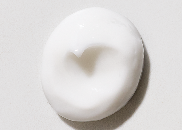 Swirl of hair mask dispensed on a white background.