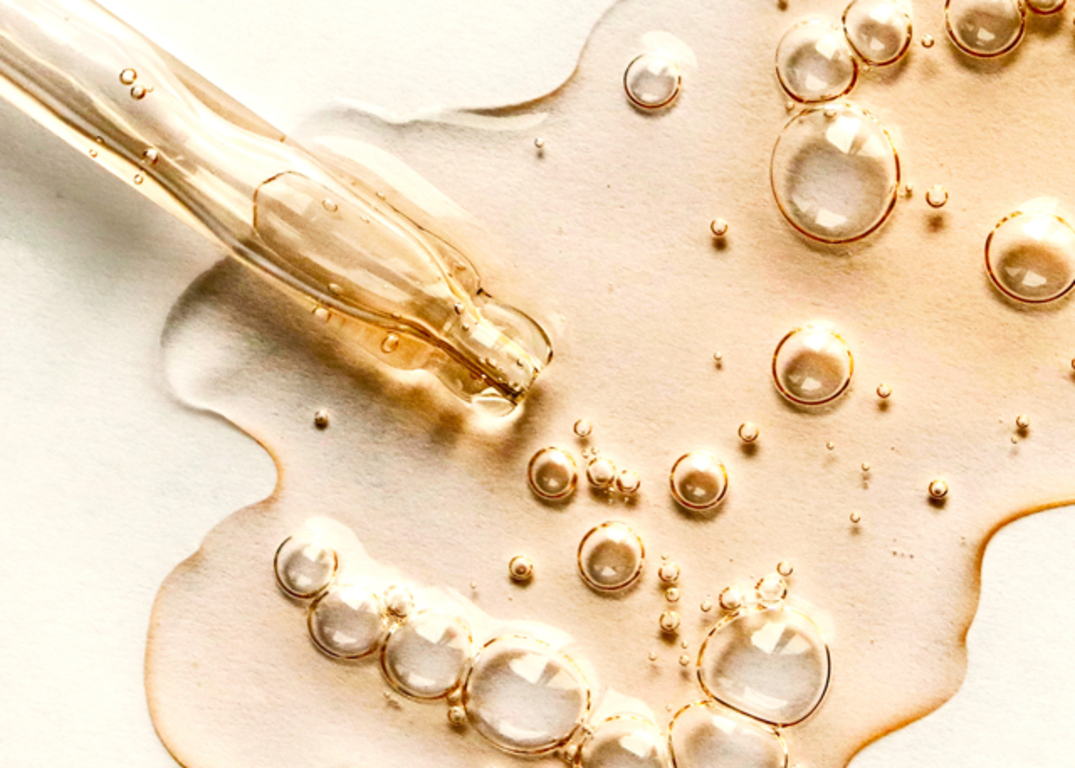Gold hot oil is spread out on a white surface.