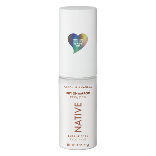 Native Coconut & Vanilla Dry Shampoo Powder in a white cylindrical bottle with a matching cap, featuring a colorful heart-shaped graphic on the cap and brown text on the lower half.